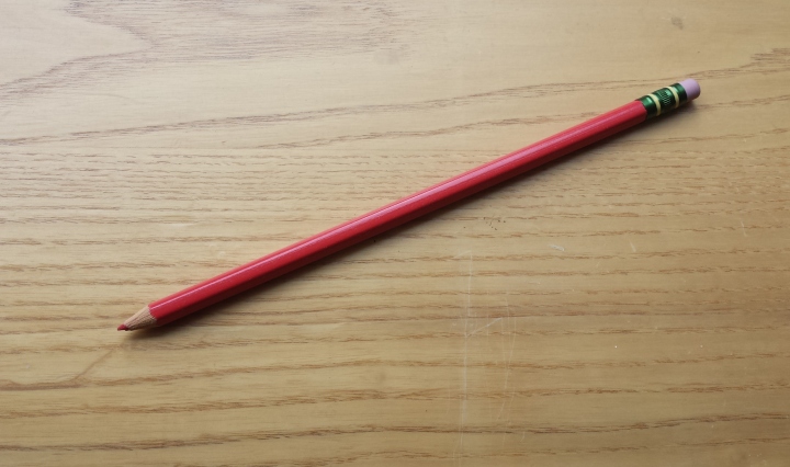 Red pencil on desk.